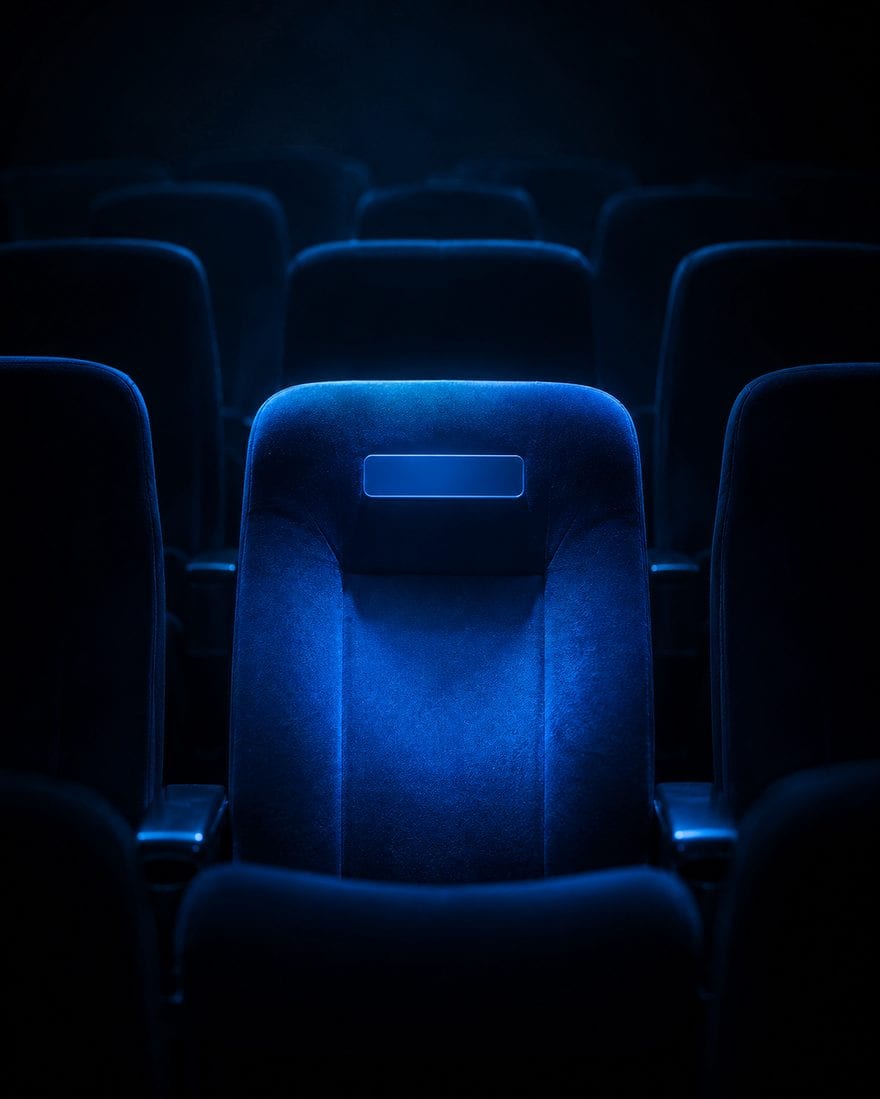 A stage washed in blue light above a silhouetted audience